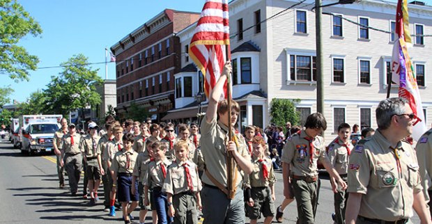 scouts marching with the american flag in a parade